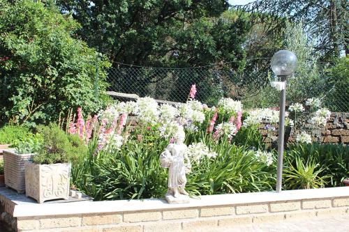 a garden with a statue in front of some flowers at Oasi di Pace in Sutri