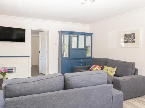 a living room with a couch and a blue cabinet at Mardan in Dumfries