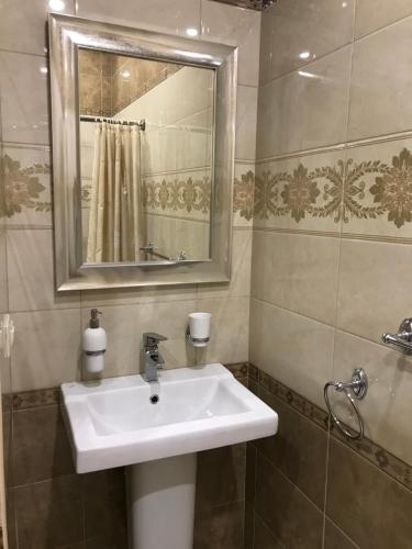 a bathroom with a white sink and a mirror at Caravan Saray in Makhachkala
