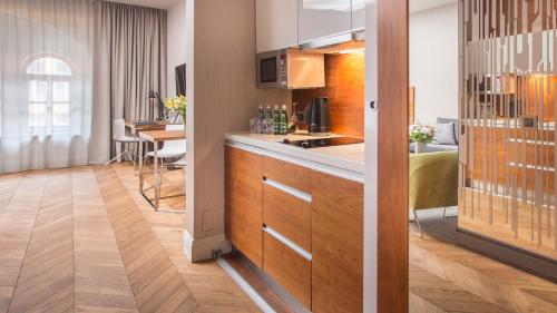 a kitchen with a counter and a living room at City Park Hotel & Residence in Poznań