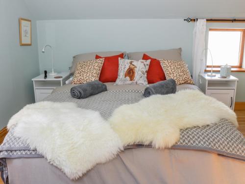 a bed with two white furry pillows on it at The Stables in Hull