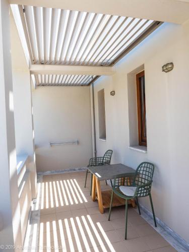 a room with a table and chairs on a patio at Mikro Livadi Special Lodges - Has an Eco Salt water pool - 150m from the beach in Episkopí- Rethimno