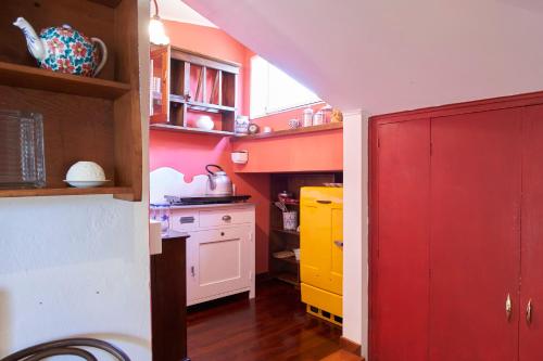 a kitchen with red and yellow cabinets and a red door at Green Nest Apartments in Florence