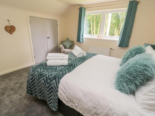 a bedroom with a bed with towels on it at Falla Farmhouse in Jedburgh