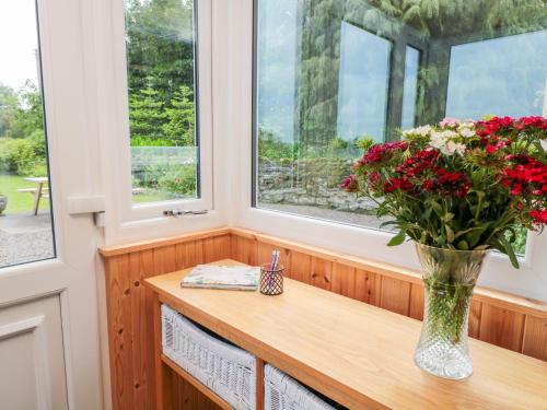 a vase of flowers sitting on a window sill at Falla Farmhouse in Jedburgh
