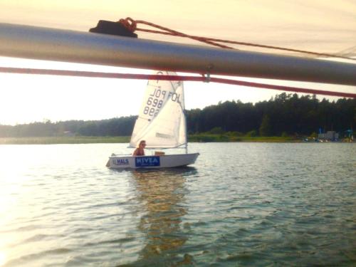 a man on a sail boat on the water at Gościniec nad Zalewem in Kąty Rybackie