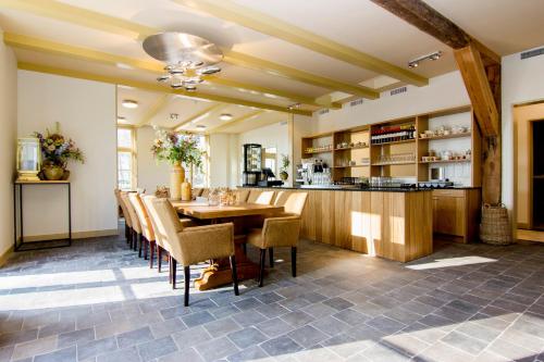a kitchen and dining room with a table and chairs at Gasterij Leyduin in Vogelenzang