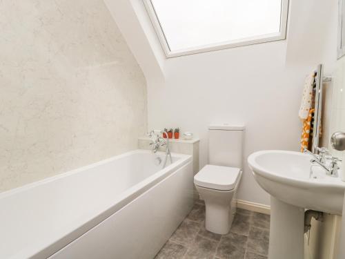 a bathroom with a tub and a toilet and a sink at Falla Farmhouse in Jedburgh