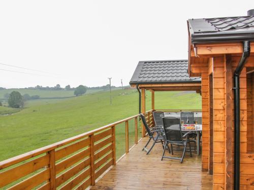 a deck with a table and chairs on a house at Manor Farm Lodges - Dragon Lodge in Newtown