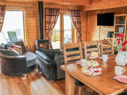 a living room with a table and a fireplace at Manor Farm Lodges - Dragon Lodge in Newtown