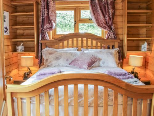 a wooden bed in a room with a window at Manor Farm Lodges - Dragon Lodge in Newtown