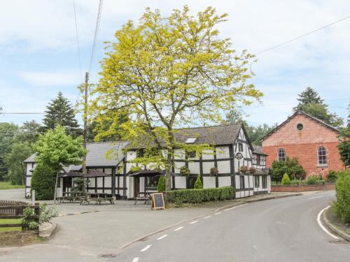 an old black and white building on the side of a road at Manor Farm Lodges - Dragon Lodge in Newtown
