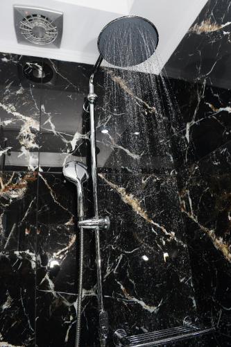 a shower with a shower head on a black counter top at Alexandros in Giannitsa
