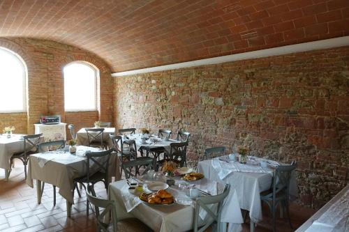 a dining room with tables and chairs and a brick wall at Agriturismo Due Comuni in San Gervasio