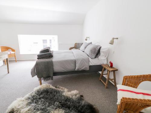 a bedroom with a bed with white sheets and pillows at Whitehall Farm Cottage in Honiton