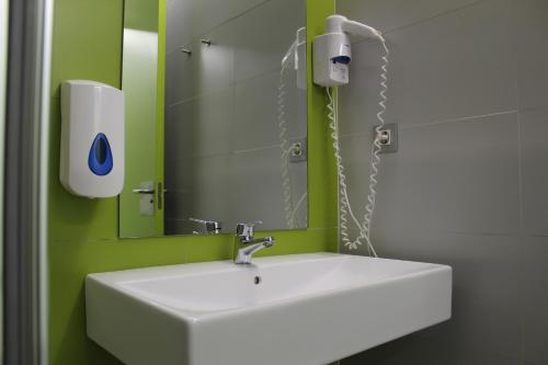 a bathroom with a white sink and a mirror at UBA Hostel in Donostia-San Sebastián