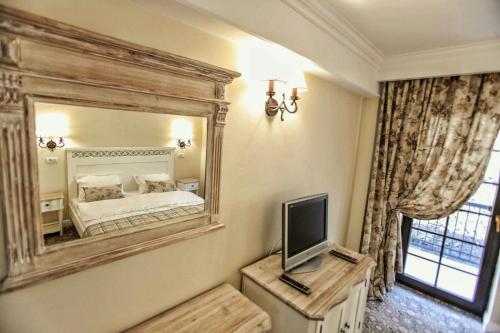 a bedroom with a large mirror and a bed at PENSIUNEA DIMITRIOS Relaxare cu jacuzzi pe Valea Cernei in Băile Herculane