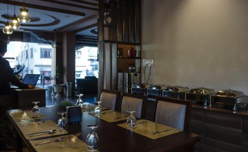 a dining room with a table and chairs and a person standing in a room at Nirvana Inn in Paro