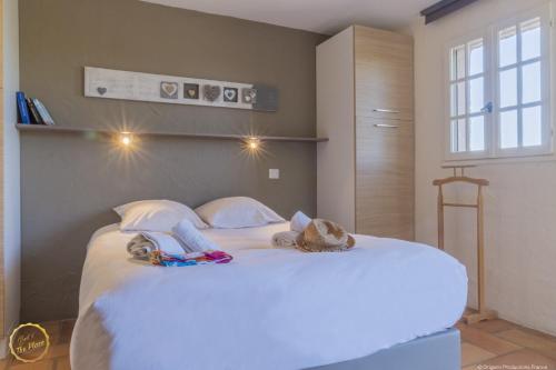 a large white bed with two stuffed animals on it at Les Garrigues de la Vallée des Baux in Paradou