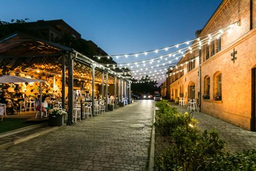 a cobblestone street with tables and chairs and lights at City Park Hotel & Residence in Poznań