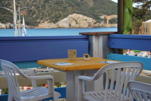 a table and chairs on a balcony with a view of the water at Hotel Giardino delle Palme in Campese