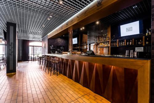 a bar in a restaurant with a counter and stools at City Park Hotel & Residence in Poznań