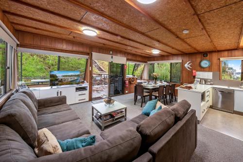 a living room with a large couch and a kitchen at Renmark River Villas and Boats & Bedzzz in Renmark
