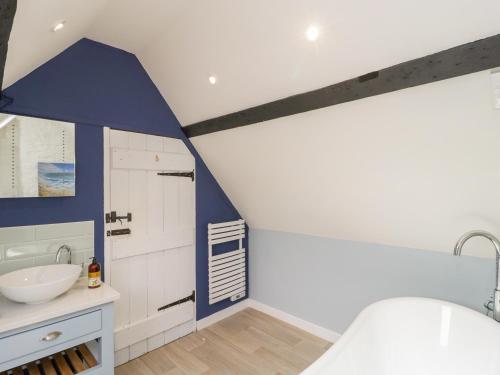ein Badezimmer mit einem weißen Waschbecken und einer Wand mit blauen Akzenten in der Unterkunft Market House in Weymouth