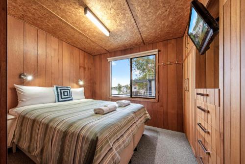 a small bedroom with a bed and a window at Renmark River Villas and Boats & Bedzzz in Renmark