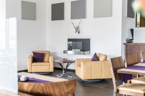 a living room with two chairs and a table at Hotel Rieder in Wiesemscheid