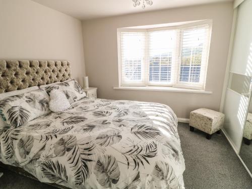 a bedroom with a bed with a blanket with palm leaves at Cranny Corner in Ballymena