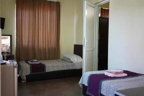a bedroom with two beds and a mirror at Ponto Hotel in Kobuleti