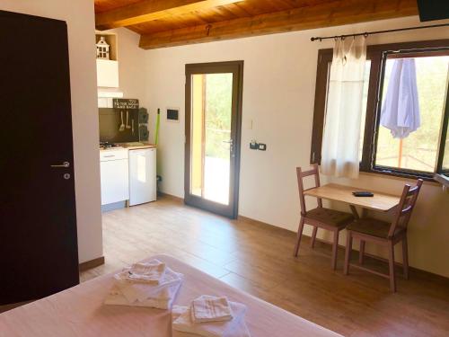 a living room with a table and a kitchen at Cuore Della Valle in Cefalù