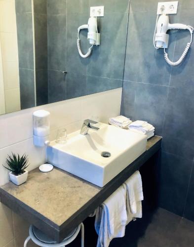a bathroom with a sink and a mirror at Hotel Botanico de Coimbra in Coimbra