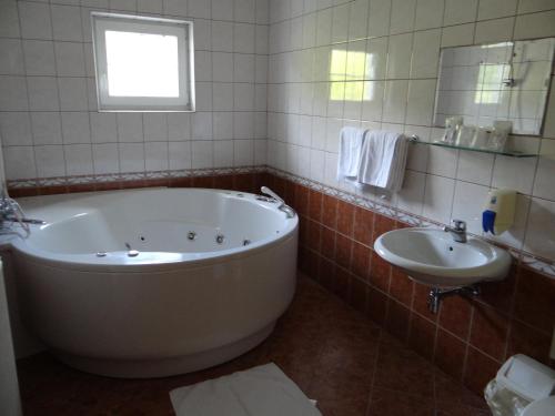 a bathroom with a large tub and a sink at Rooms Hochkraut in Celje