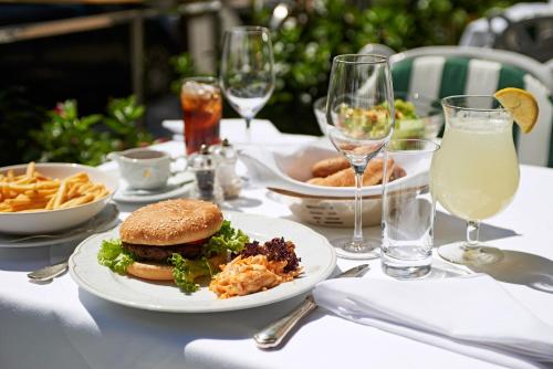 a table with a sandwich and french fries and drinks at Grand Hotel Wien in Vienna