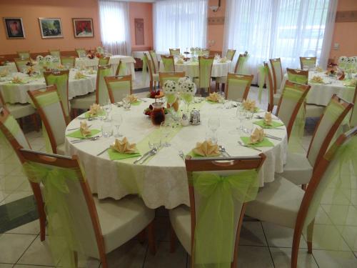 a dining room with white tables and chairs with flowers at Rooms Hochkraut in Celje