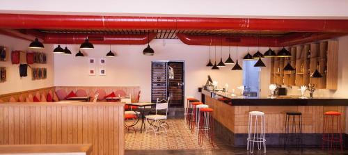 a restaurant with a bar with orange stools at Marrakech Ryads Parc All inclusive in Marrakech