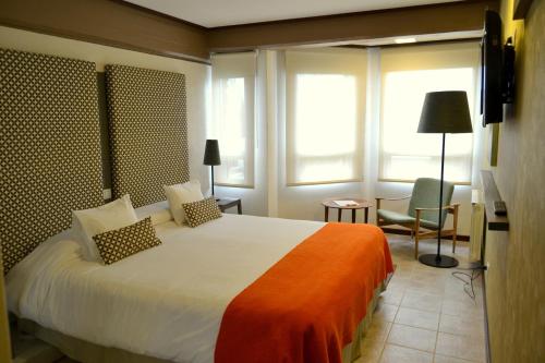 Una cama o camas en una habitación de Hotel ACA El Calafate