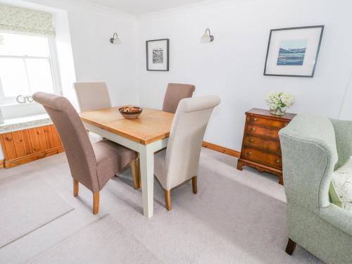 a dining room with a wooden table and chairs at Bryn Haf, New Street in Beaumaris