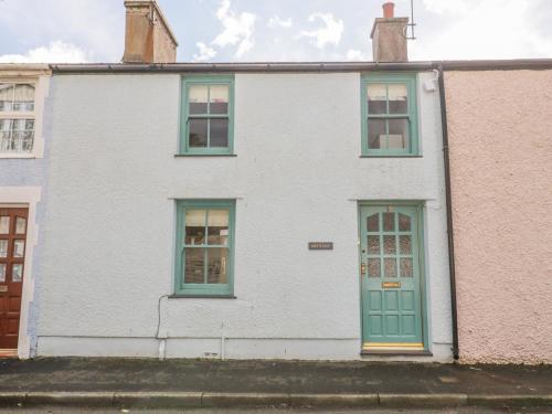 a white house with green doors and windows at Bryn Haf, New Street in Beaumaris