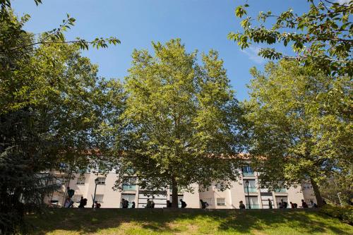 a building with trees in front of it at Hotel San Lázaro in Santiago de Compostela