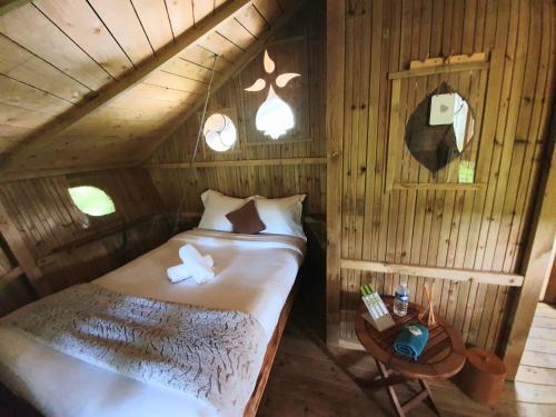 une petite chambre avec un lit et une table dans l'établissement Le Petit Moulin du Rouvre, à Saint-Pierre-de-Plesguen
