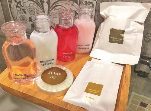 a wooden shelf with several bottles of soap and liquids at Mango House in Sukhothai