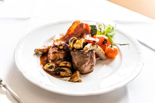 a plate of food with meat and vegetables on a table at Hotel Rieder in Wiesemscheid