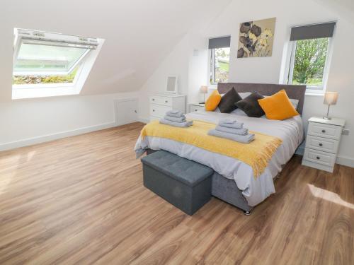 Un dormitorio con una cama grande y suelos de madera. en Llwyd Coed Canol, en Caernarfon