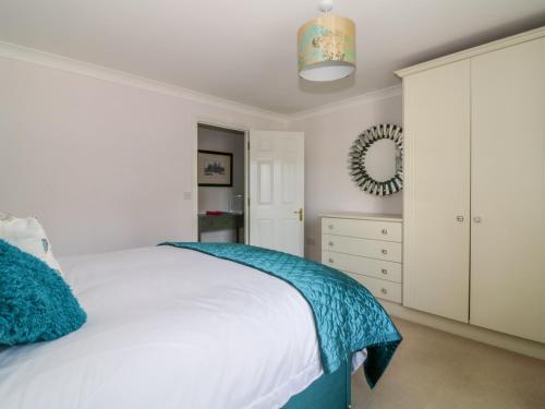 a bedroom with a white bed and a mirror at The Hoist in Ely