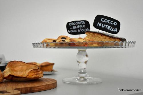 een schaal met gebak op een etagère met een taart bij Les 3 Chambres in Lecce