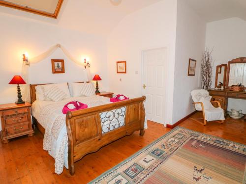 ein Schlafzimmer mit einem Bett mit rosa Kissen darauf in der Unterkunft Woodleigh Cottage in Ballycastle