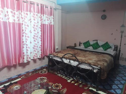 a bedroom with a bed with pink and green pillows at Vamoose Quaint Wood Cottage in Darjeeling